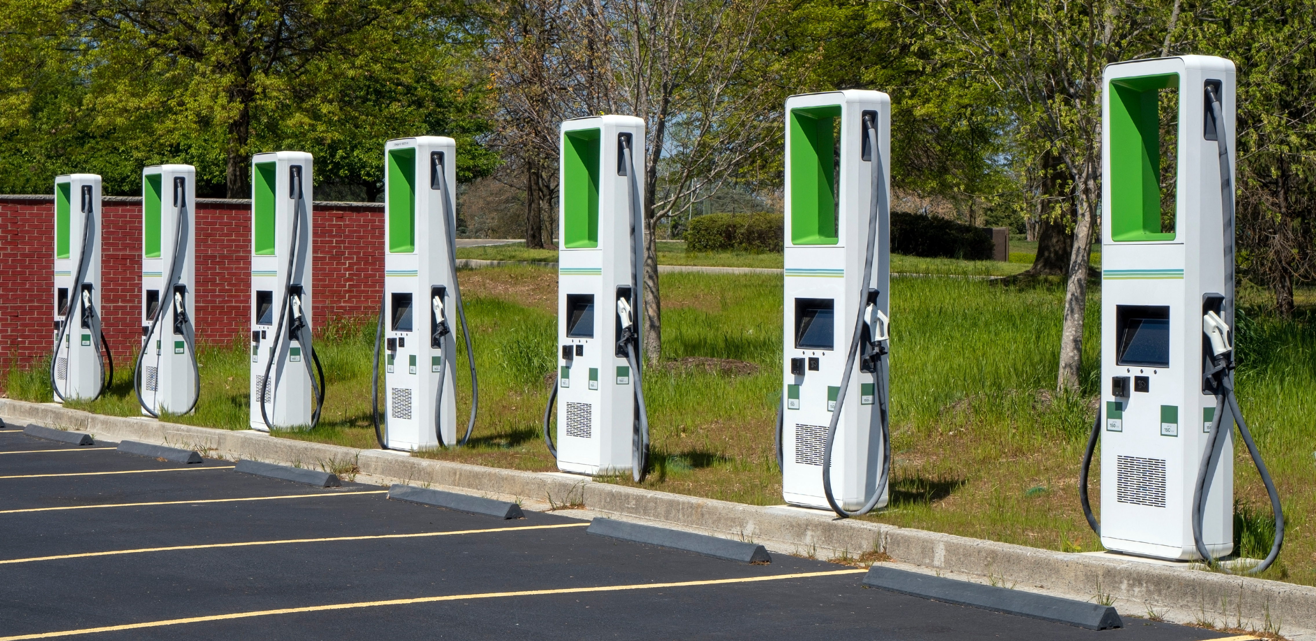 Row of electric vehicle charging stations installed in a commercial parking lot
