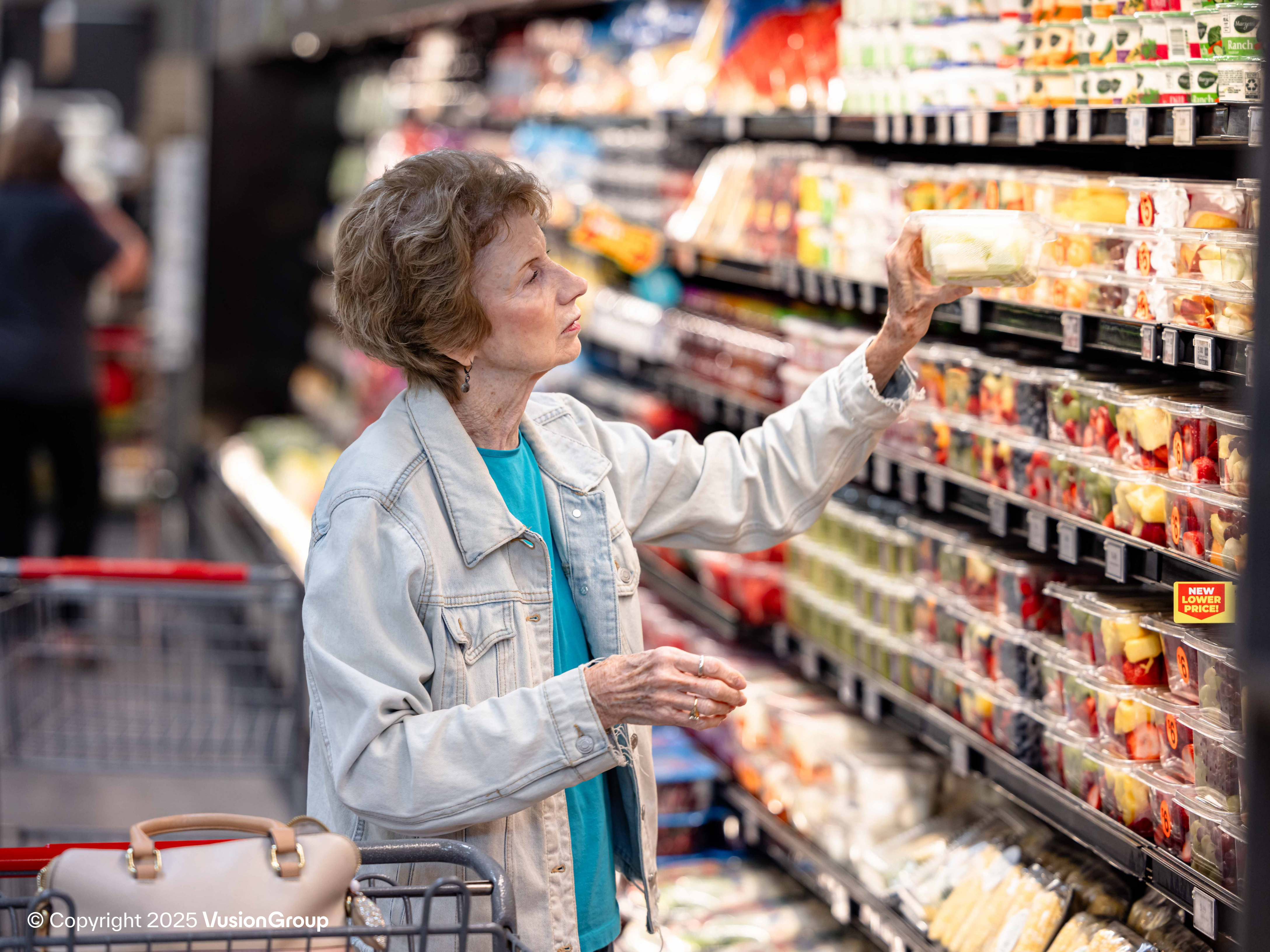 Customer picking up cooled grocery item from shelf with Electronic Shelf Labels